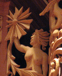 Carved wood sculpture of female figure with sunburst and sea monster,  Pacific Lutheran University, Tacoma WA, wood sculptor Jude Fritts
