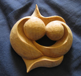Hand-held meditation carving, two heads touching with intertwined hearts